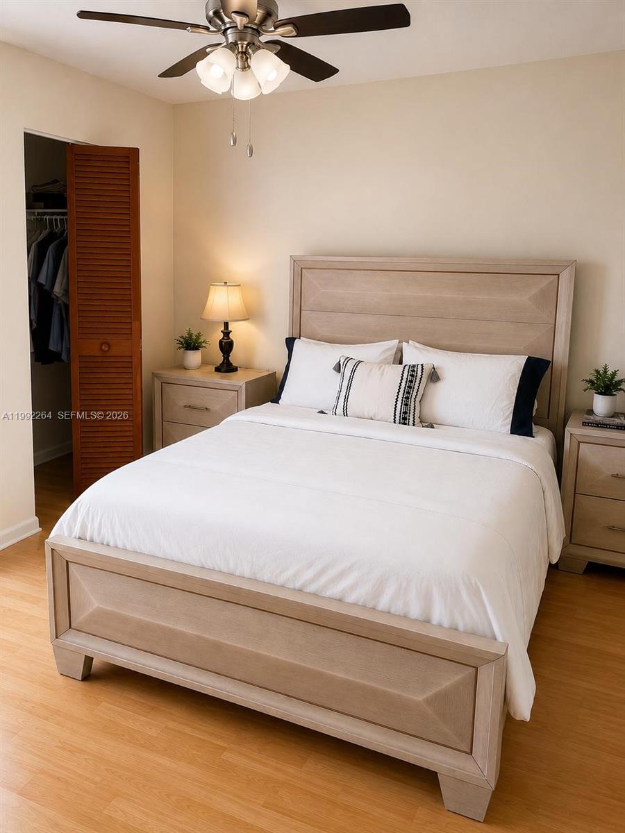 A bedroom features a wooden bed frame, two nightstands, and a ceiling fan — 10060 NW 41st St # 5, Doral FL 33178, DORAL, FL