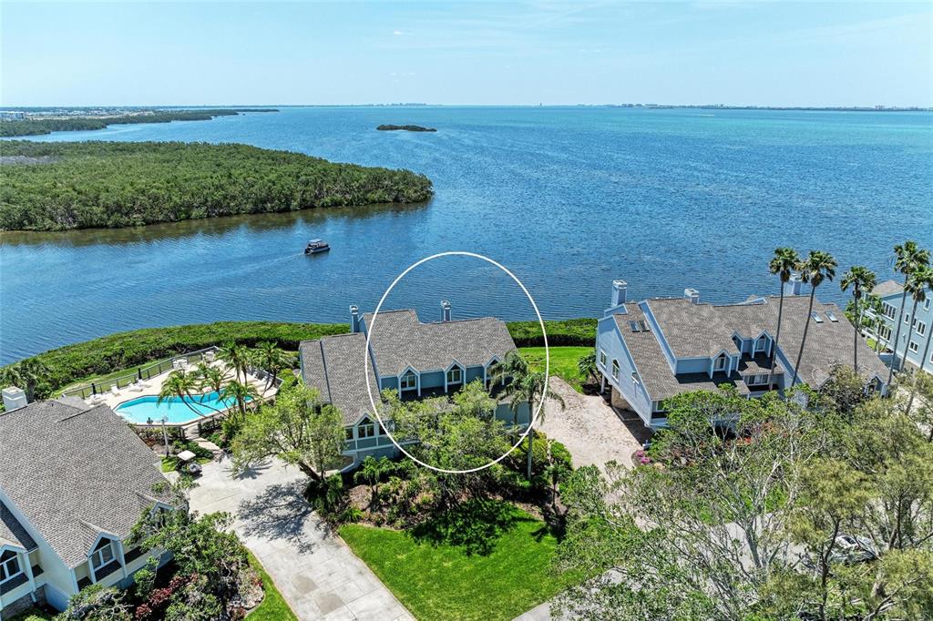 An aerial view shows a multi-story residential building with a shingled roof near water — 12 TIDY ISLAND BOULEVARD, BRADENTON, FL