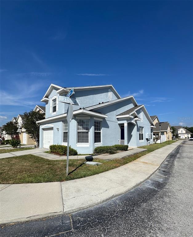 A two-story light blue house with a garage sits on a corner lot — 9701 CARLSDALE DRIVE, RIVERVIEW, FL