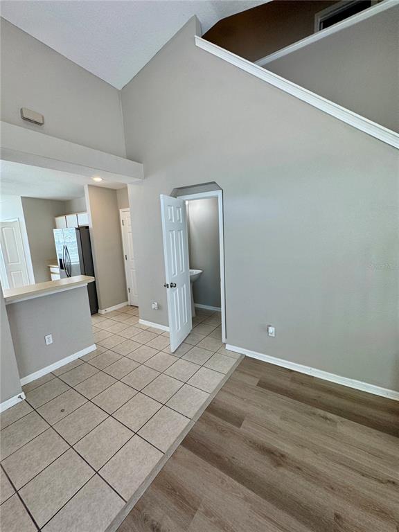 An interior view shows a kitchen with tile flooring, a half-bathroom, and wood-look flooring — 9701 CARLSDALE DRIVE, RIVERVIEW, FL