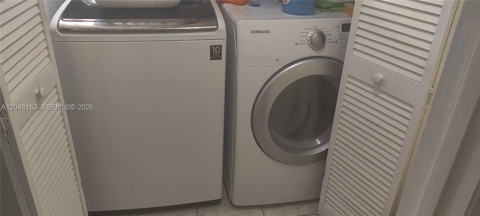 A white washing machine and a Samsung dryer are positioned inside a laundry closet — 14063 SW 177th St, Miami FL 33177, MIAMI, FL