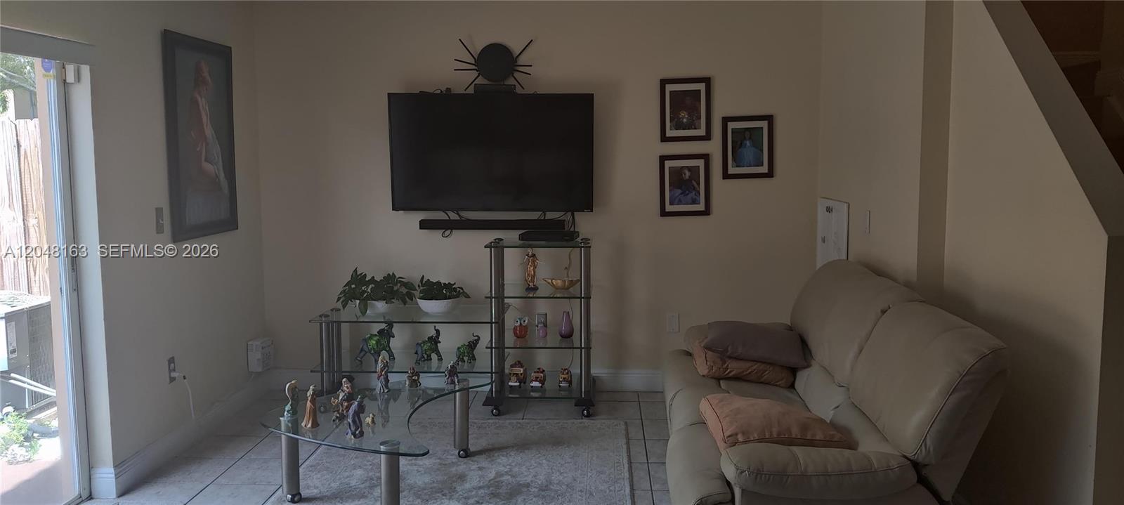 A living room features a beige sofa, a glass coffee table, and a wall-mounted television — 14063 SW 177th St, Miami FL 33177, MIAMI, FL