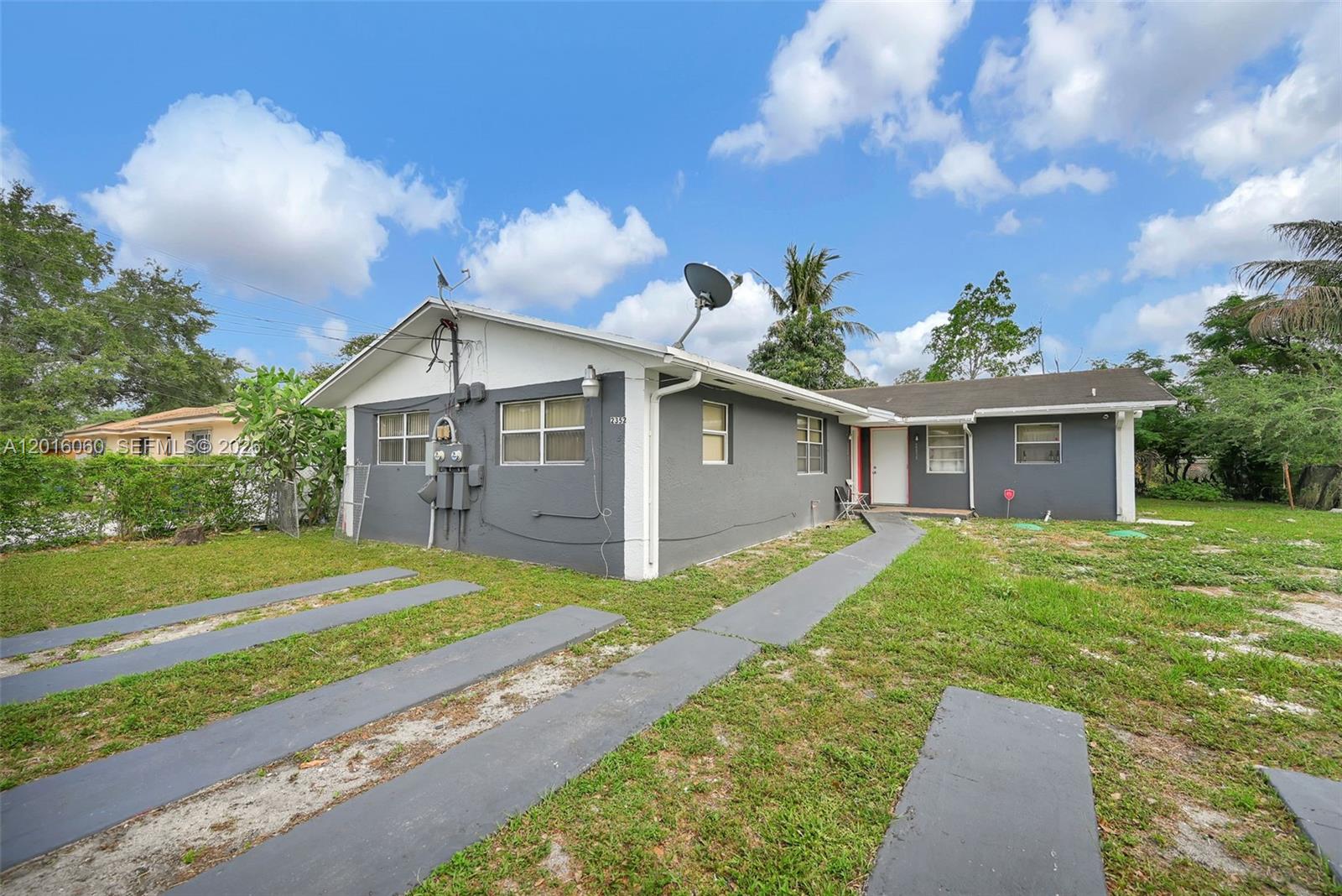 A gray single-story house with a white trim and a paved driveway in the yard — 2352 NW 102nd St, Miami FL 33147, MIAMI, FL