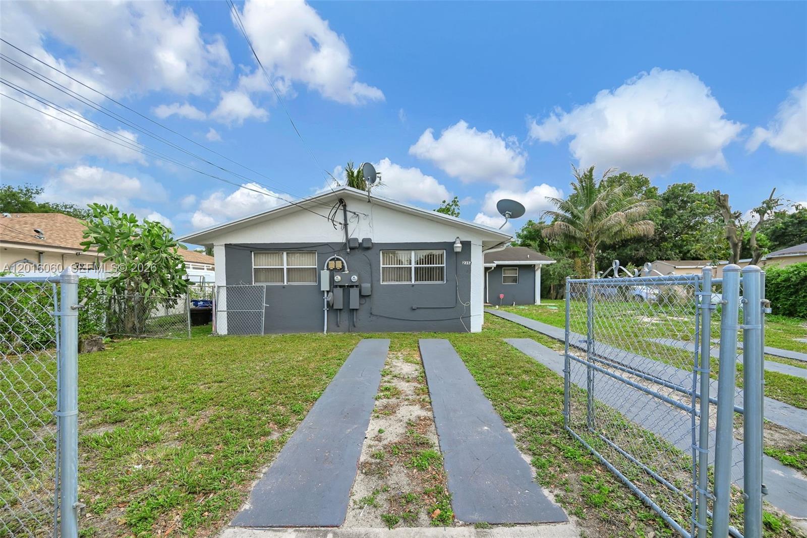 A single-story house with a gray exterior, two windows, and a paved driveway — 2352 NW 102nd St, Miami FL 33147, MIAMI, FL