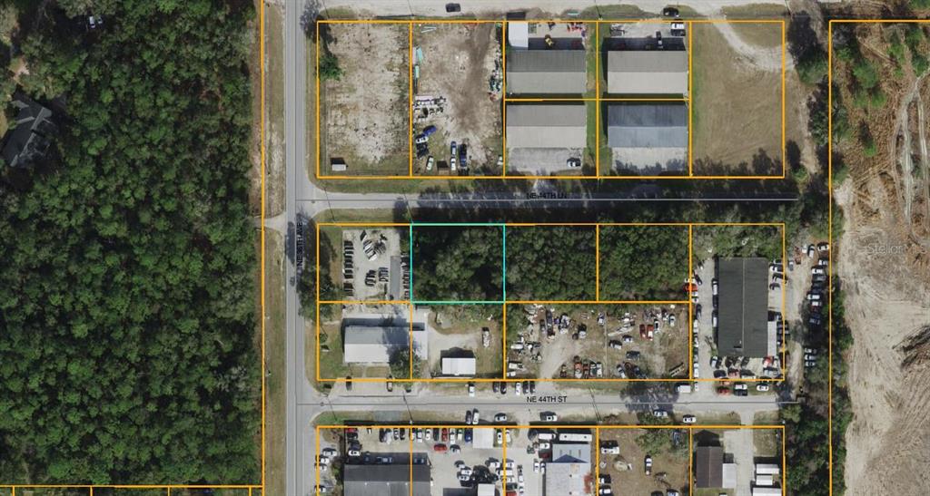This aerial map shows a rectangular plot of land highlighted among surrounding commercial properties — NE 44TH LANE, OCALA, FL