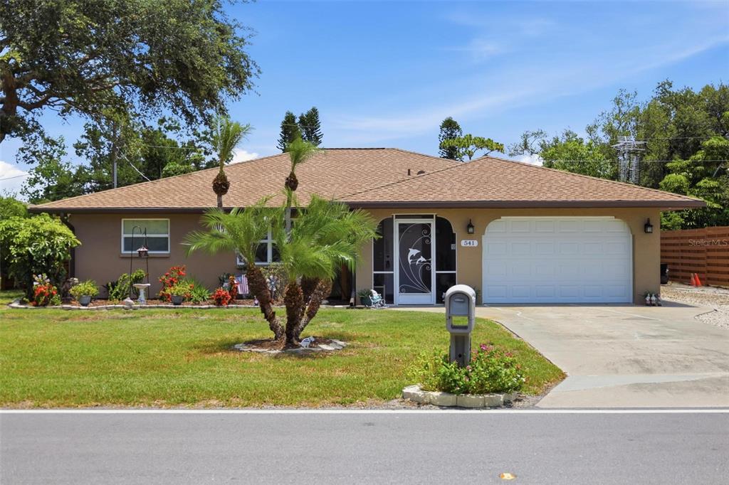 A single-story house with a brown exterior, a brown shingled roof, and a white garage door — 541 MORNINGSIDE ROAD, VENICE, FL