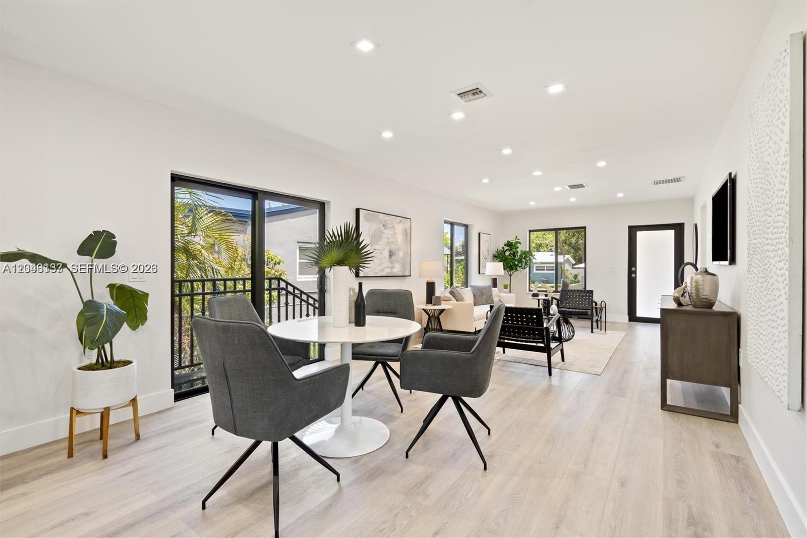 A bright, open-concept living and dining area features light wood floors and modern furniture — 222 SW 3rd Ter, Dania Beach FL 33004, DANIA BEACH, FL