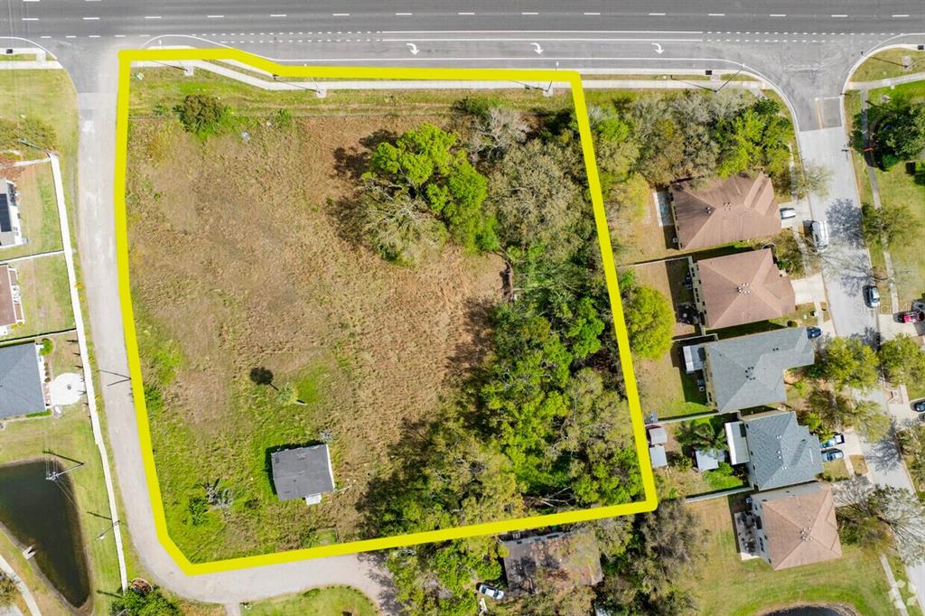 An aerial view shows a large, vacant, partially wooded lot outlined in yellow near houses — 11005 S 301 HIGHWAY, RIVERVIEW, FL