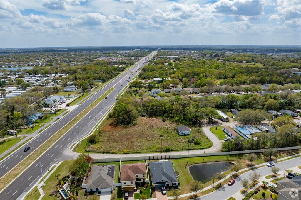 An aerial view shows a vacant lot adjacent to a multi-lane highway and residential neighborhood — 11005 S 301 HIGHWAY, RIVERVIEW, FL