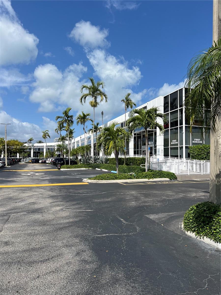 A modern office building with glass windows is surrounded by palm trees and a parking lot — 260 Crandon Blvd # A51, Key Biscayne FL 33149, KEY BISCAYNE, FL