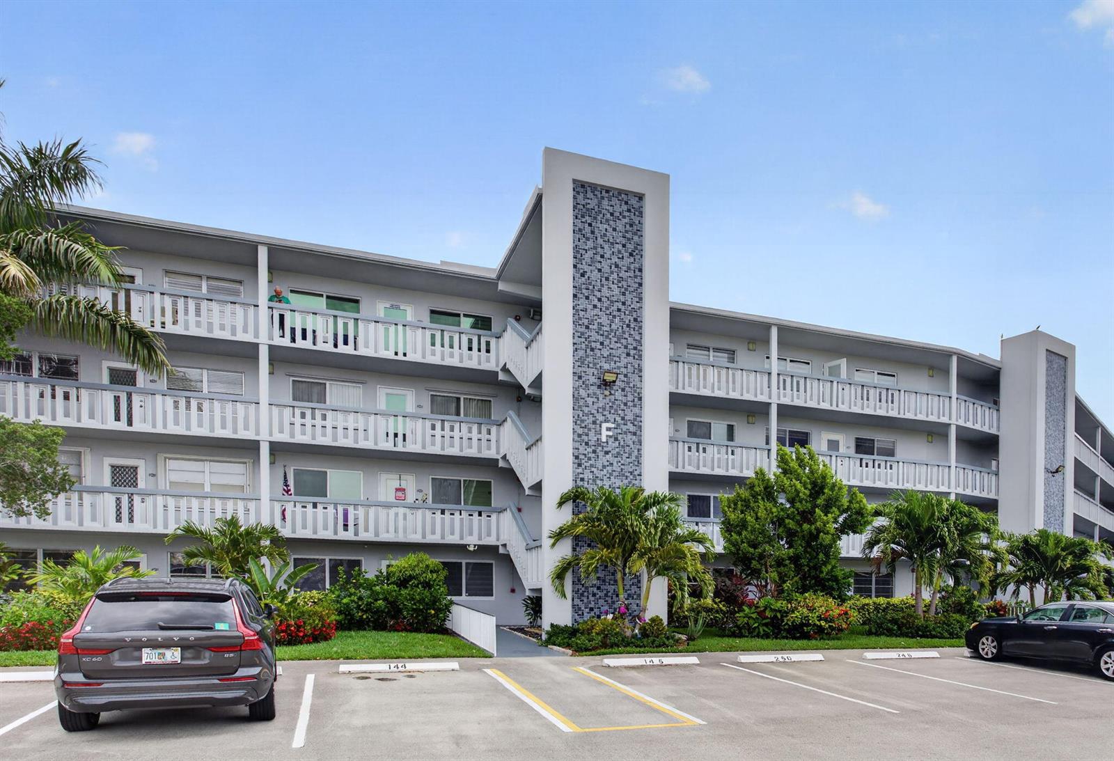 A multi-story apartment building with a gray facade, white balconies, and a central tiled pillar — 446 Richmond F, Deerfield Beach FL 33442, DEERFIELD BEACH, FL