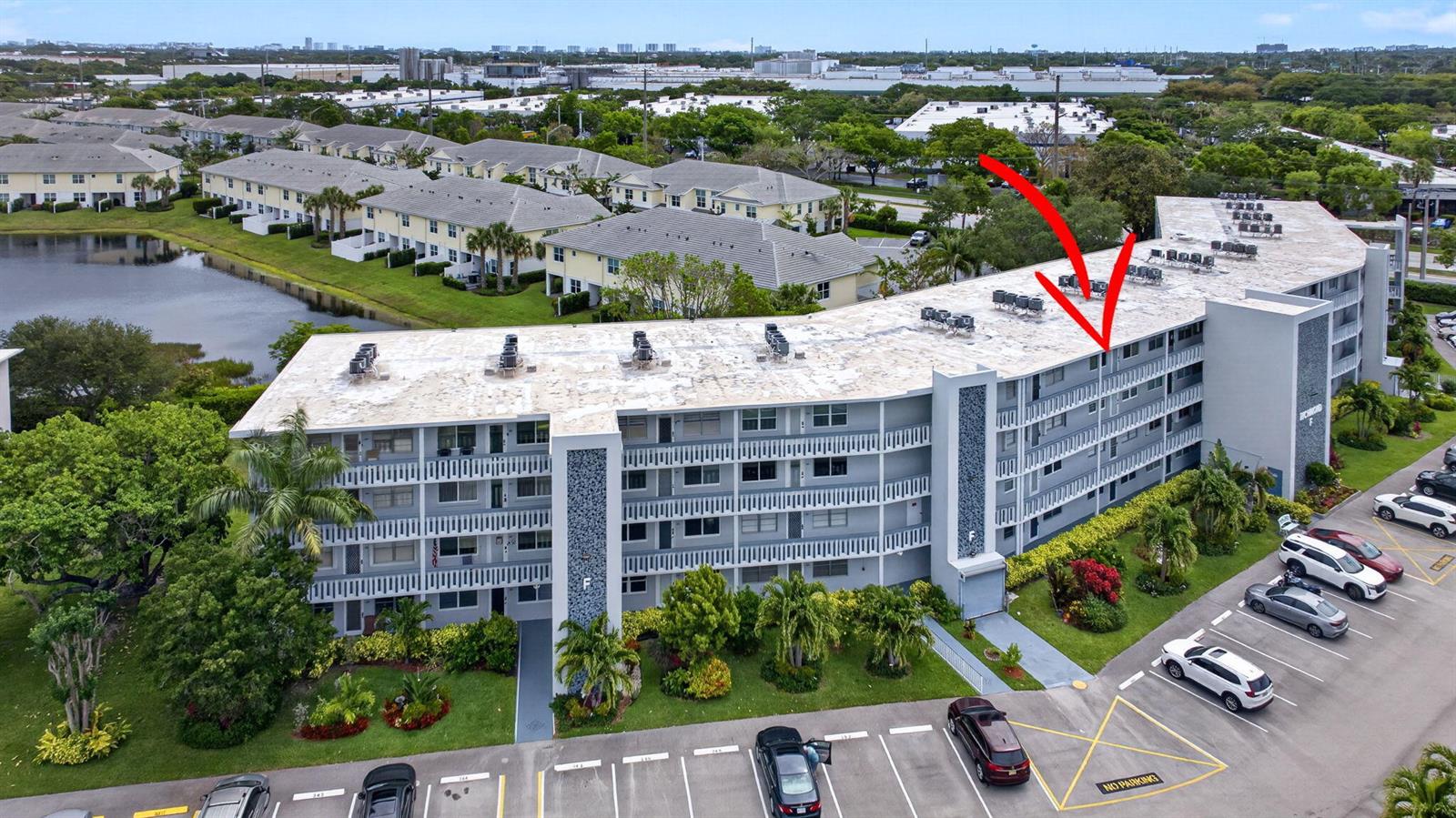 An aerial view of a multi-story apartment building with a red arrow pointing toward it — 446 Richmond F, Deerfield Beach FL 33442, DEERFIELD BEACH, FL