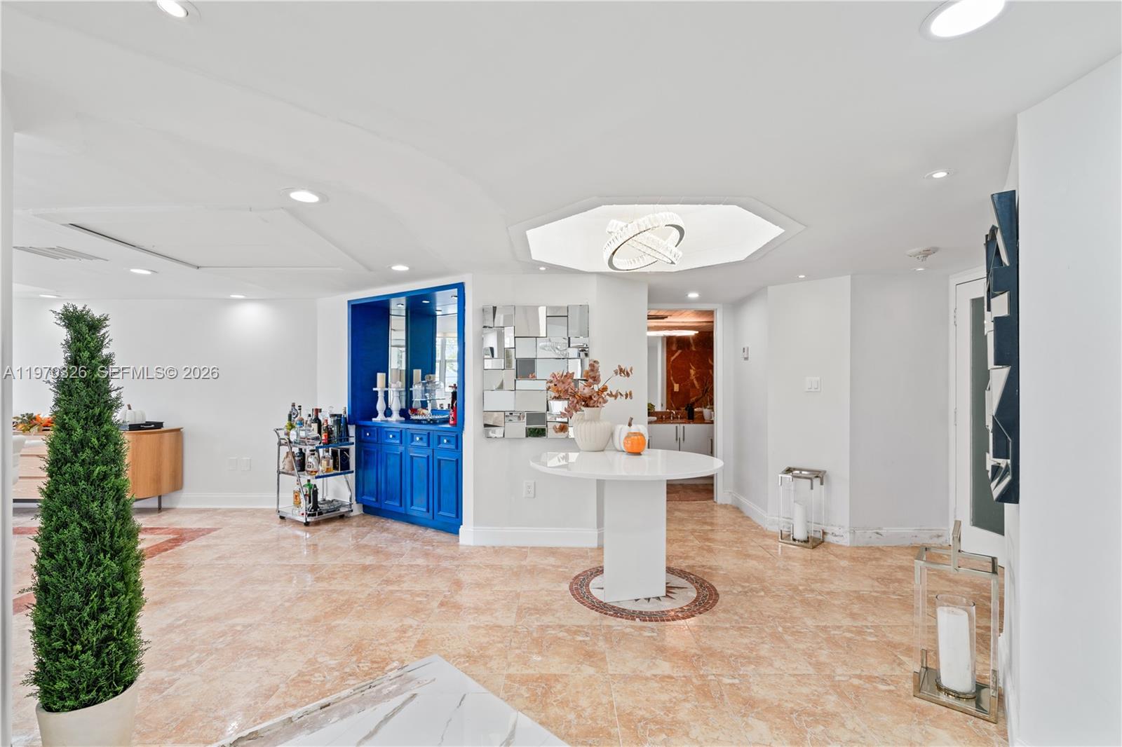 A bright foyer features a blue built-in bar, a round table, and marble tile flooring — 905 Brickell Bay Dr # 230, Miami FL 33131, MIAMI, FL