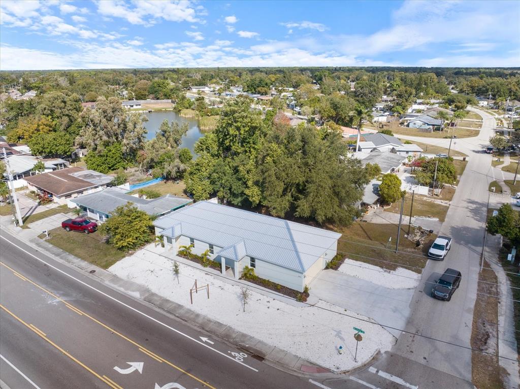 An aerial view shows a single-story house with a metal roof near a road — 3525 MCINTOSH ROAD, SARASOTA, FL