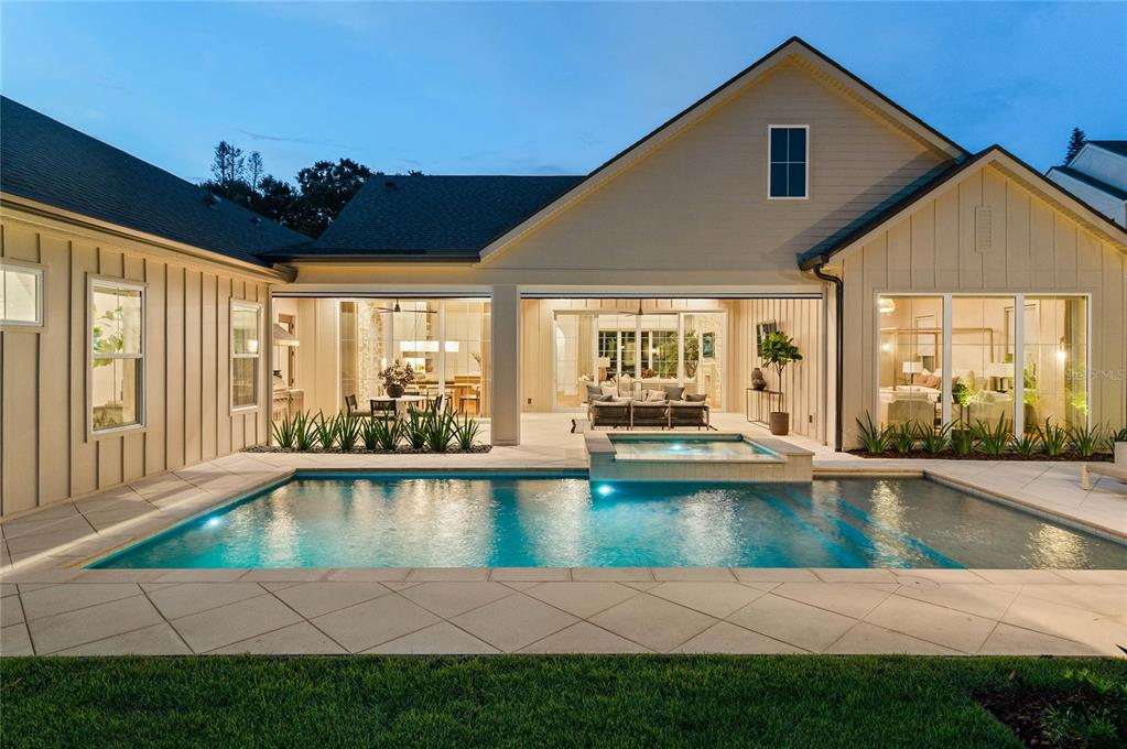 A modern house exterior features a swimming pool, a hot tub, and a covered patio — 1204 NOTTINGHAM STREET, ORLANDO, FL
