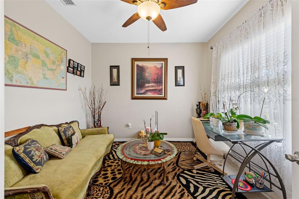 A room with a green sofa, a round coffee table, a desk, and a patterned rug — 1751 WALTRIP STREET, NORTH PORT, FL