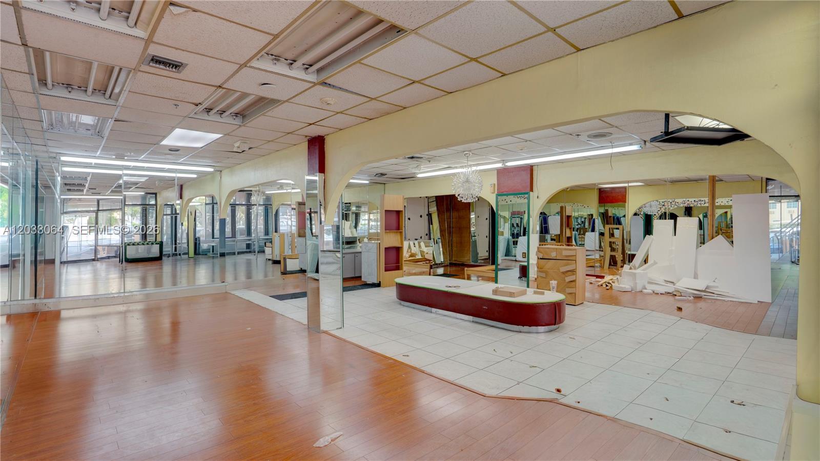 An empty commercial space features wood-look flooring, white tile sections, and arched room dividers — 314 SW 12 Ave, Miami FL 33130, MIAMI, FL