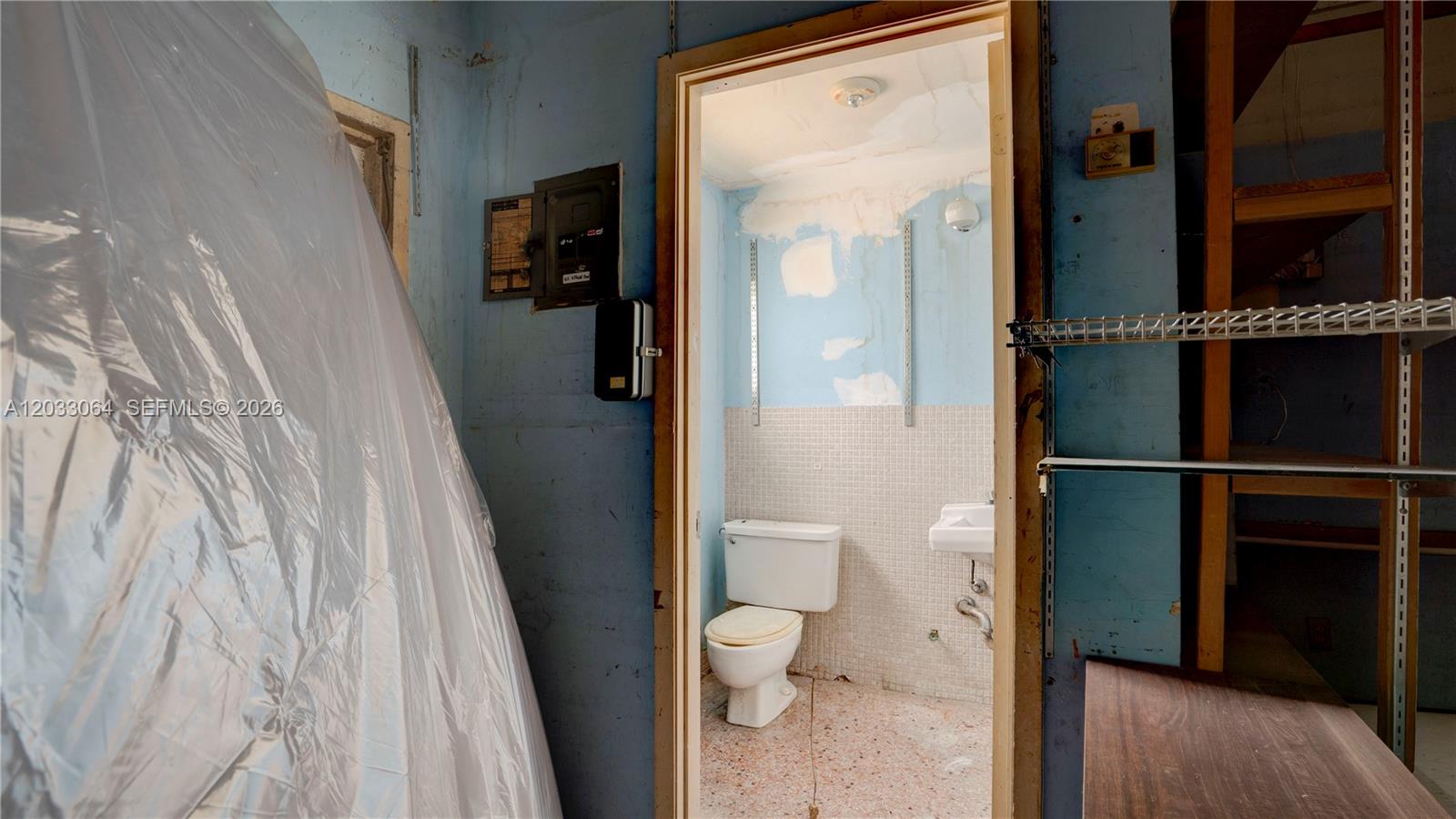 A small, unfinished bathroom with a toilet and sink is visible through a doorway — 314 SW 12 Ave, Miami FL 33130, MIAMI, FL
