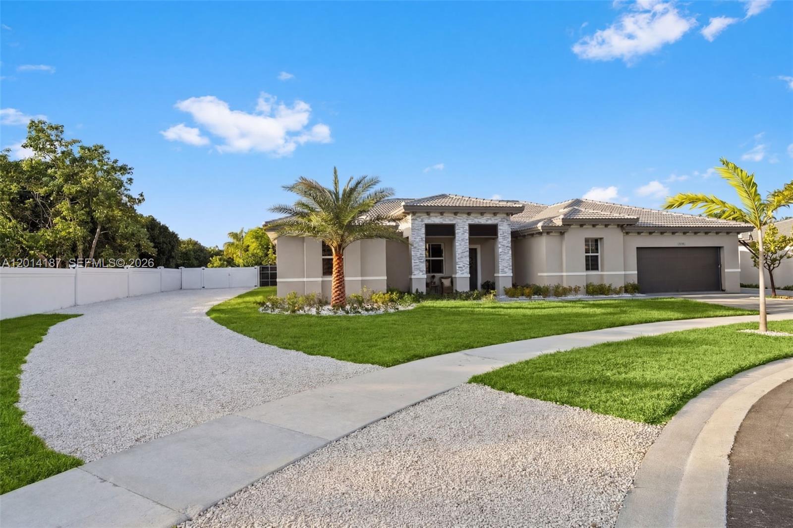A single-story house with a gravel driveway, a palm tree, and a stone-accented entryway — 13283 SW 188th Ter, Miami FL 33177, MIAMI, FL