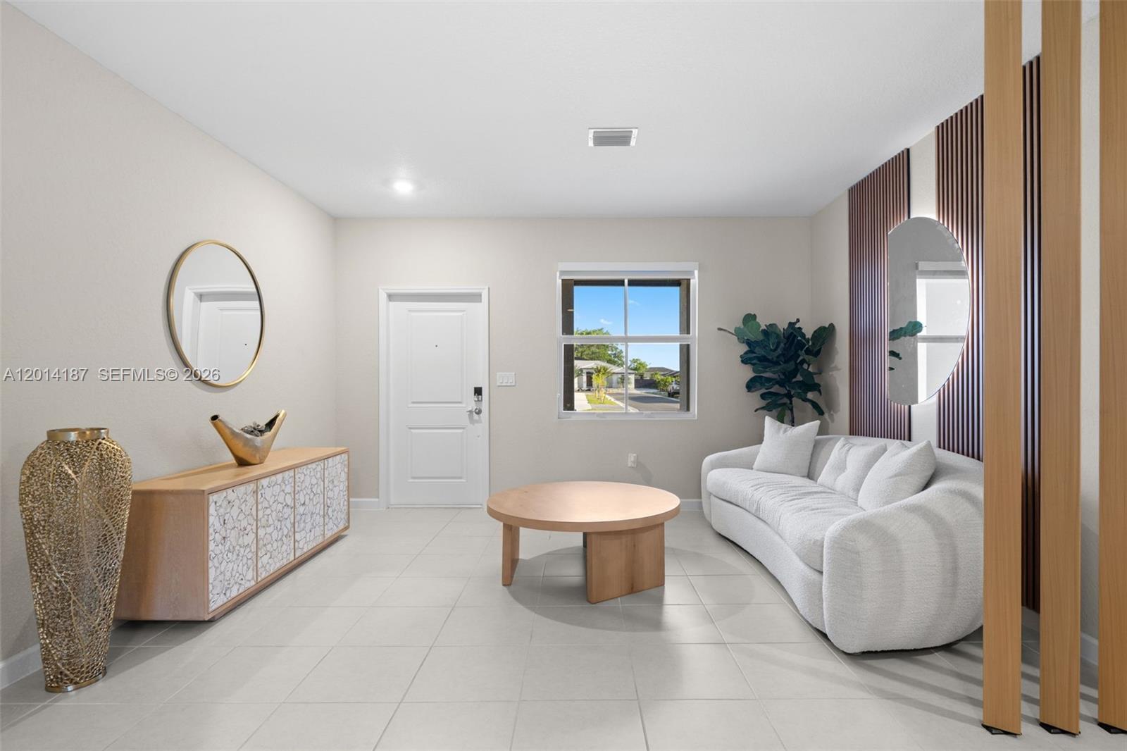 A living room features a white sofa, a round wooden coffee table, and a console table — 13283 SW 188th Ter, Miami FL 33177, MIAMI, FL