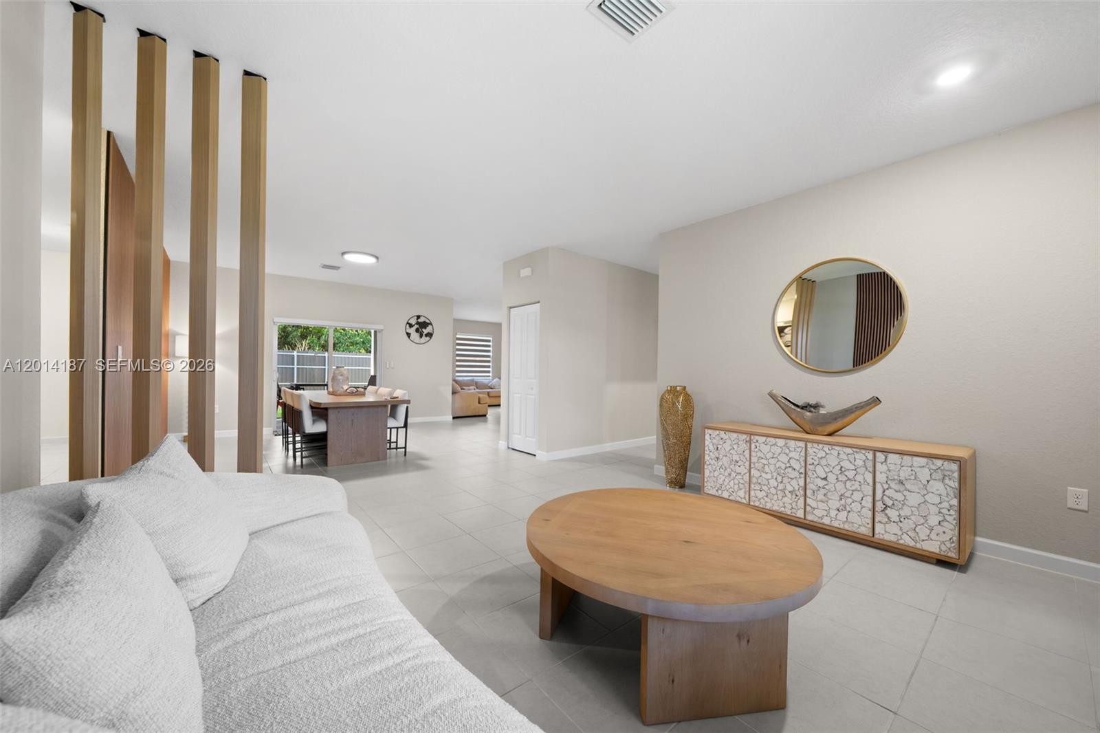 A living room features a light-colored sofa, a wooden coffee table, and a dining area — 13283 SW 188th Ter, Miami FL 33177, MIAMI, FL