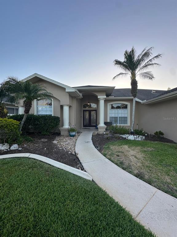 A single-story house with a concrete walkway, two palm trees, and a covered entryway — 23218 CYPRESS TRAIL DRIVE, LUTZ, FL