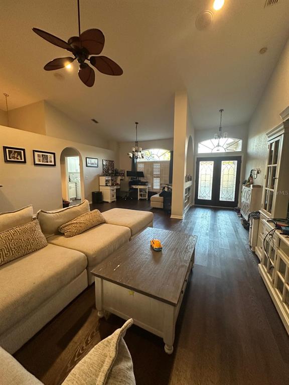 A living room features a large sectional sofa, a wooden coffee table, and dark flooring — 23218 CYPRESS TRAIL DRIVE, LUTZ, FL