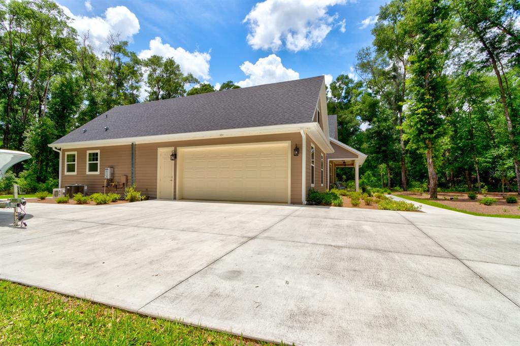 A tan house with a large concrete driveway and a two-car garage — 3504 DUNSTABLE DRIVE, DELAND, FL