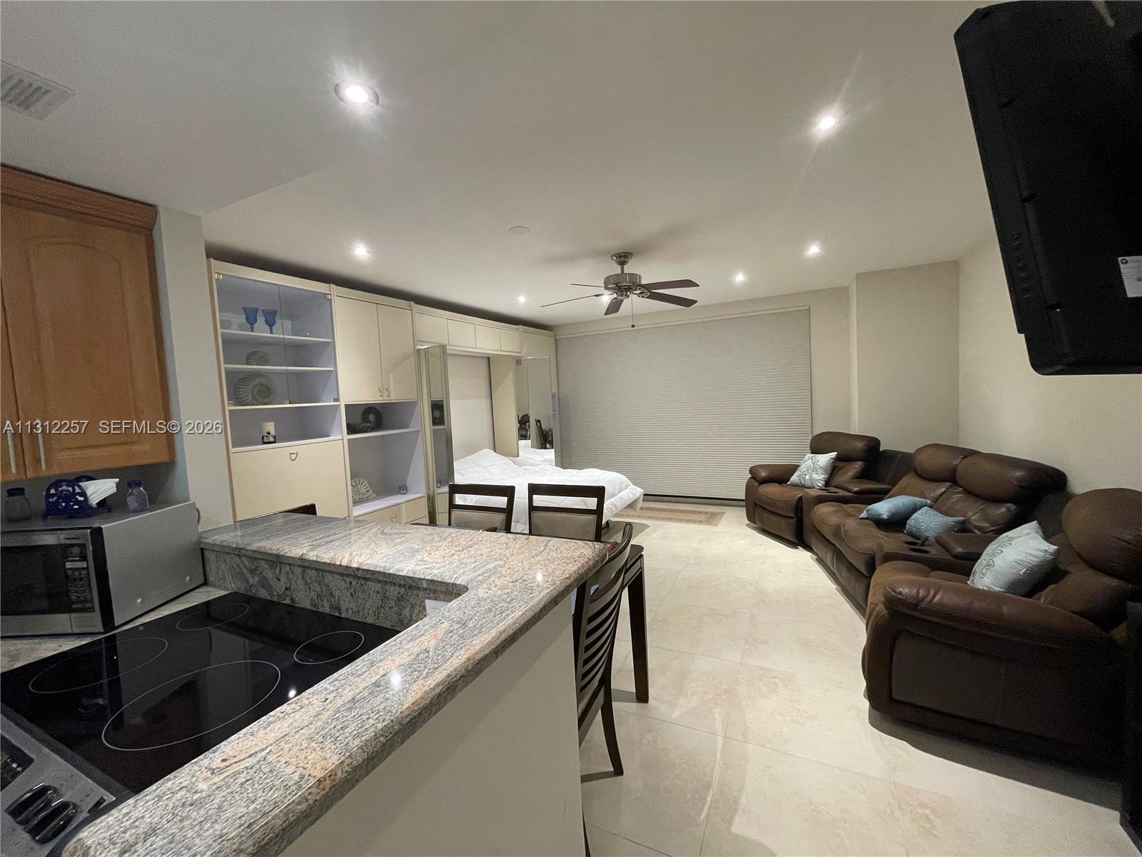 This open-concept studio apartment features a kitchen with granite countertops and a living area — 3505 S Ocean Dr # 108, Hollywood FL 33019, HOLLYWOOD, FL