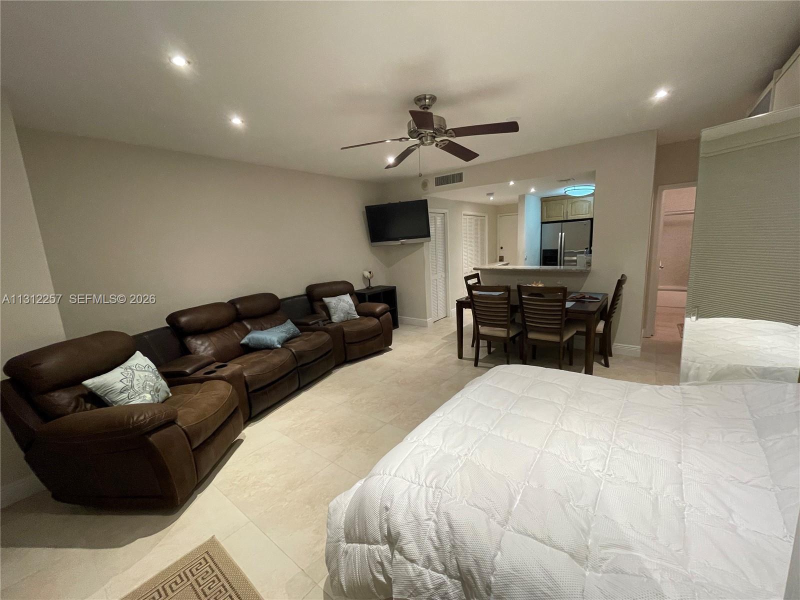 This open-concept living and dining area features tile flooring, leather seating, and a ceiling fan — 3505 S Ocean Dr # 108, Hollywood FL 33019, HOLLYWOOD, FL