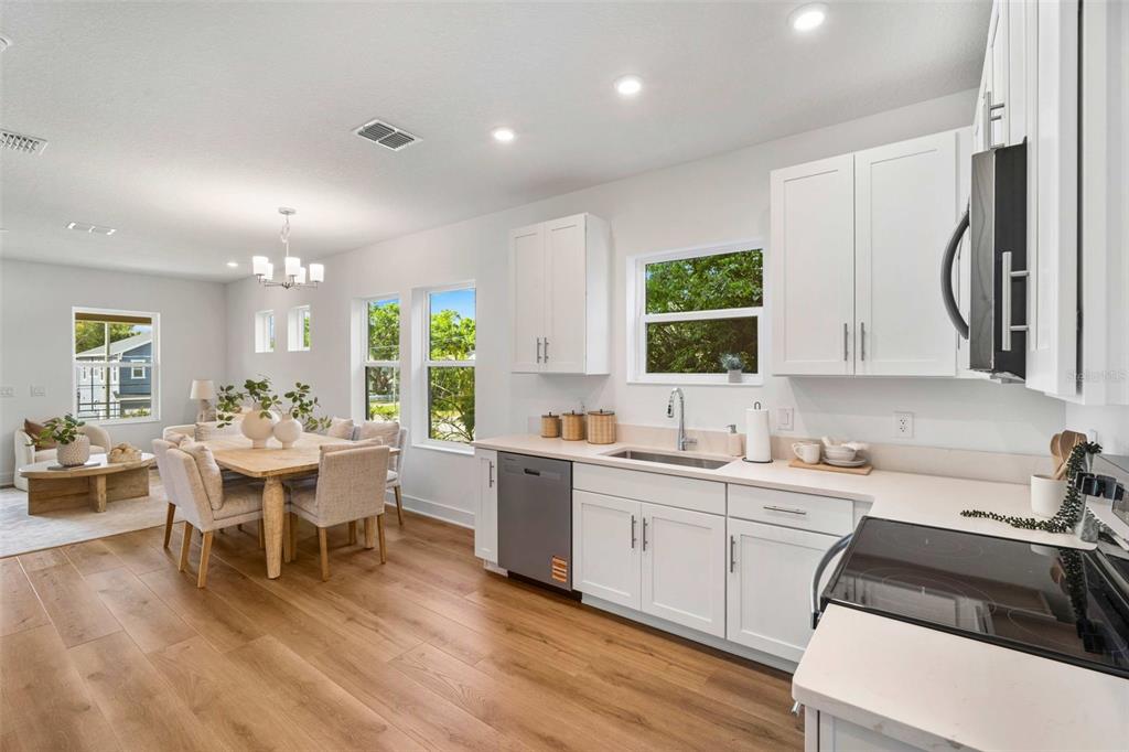 A bright kitchen with white cabinets and stainless steel appliances opens to a dining area — 2711 W NORTH B STREET UNIT 2, TAMPA, FL