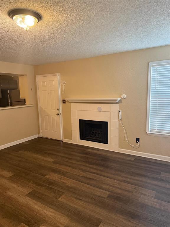 A living room features wood-look flooring, a white fireplace, and a door leading outside — 4400 THORNBRIAR LANE UNIT 102, ORLANDO, FL
