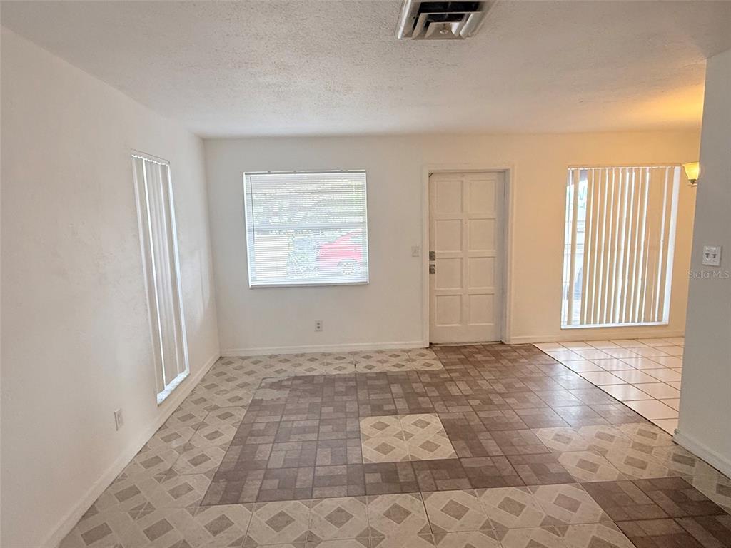 An interior view of a room with tiled floors, a white door, and large windows — 1100 70TH STREET N UNIT 4, ST PETERSBURG, FL