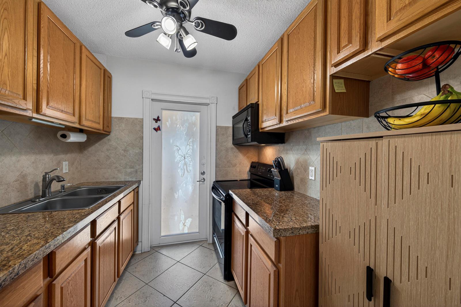 A living and dining area features dark wood floors, leather furniture, and a stainless refrigerator — 2475 W Golf Boulevard # 247, Pompano Beach FL 33064, POMPANO BEACH, FL