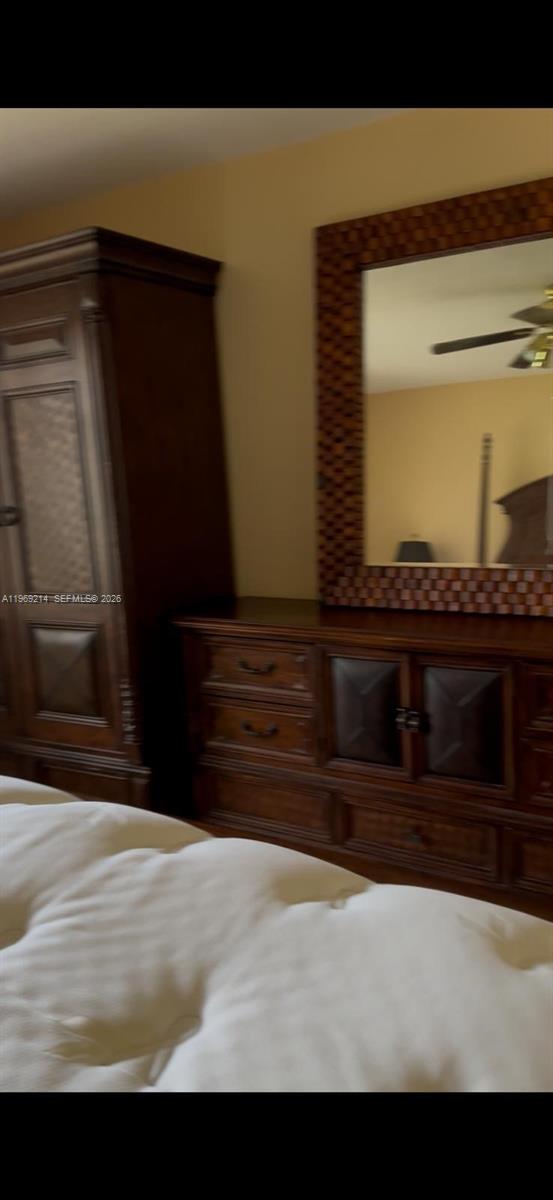 A bedroom features a large wooden armoire, a matching dresser, and a decorative wall mirror — 18 SW 13th St, Dania Beach FL 33004, DANIA BEACH, FL