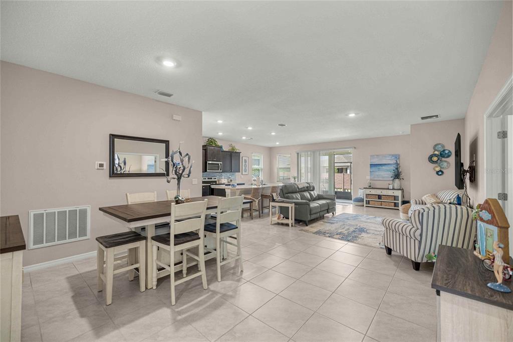 An open-concept living area features a dining table, kitchen island, and a casual seating space — 4312 NW 55TH COURT, OCALA, FL