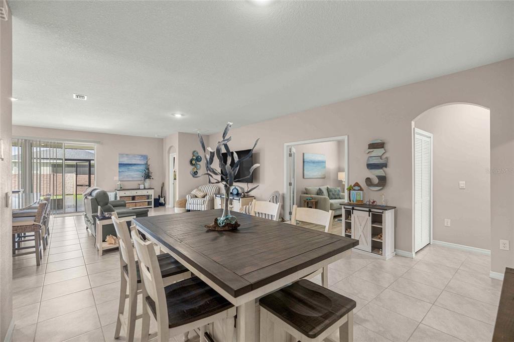 A dining area with a dark wood table sits in front of a living room — 4312 NW 55TH COURT, OCALA, FL