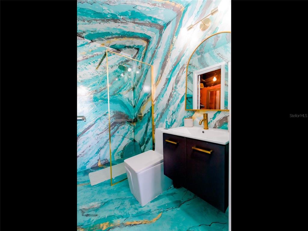 A bathroom features vibrant turquoise marble-patterned walls and floors with gold-toned fixtures and hardware — 200 AVENIDA MARINA VIEW DOS MARINAS II UNIT 2706, FAJARDO, PR