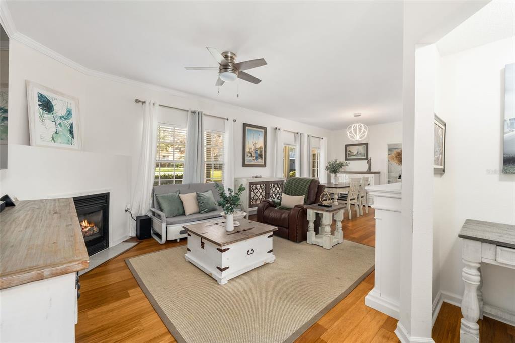 A living room with a fireplace, hardwood floors, a ceiling fan, and an adjacent dining area — 10000 SW 52ND AVENUE UNIT 35, GAINESVILLE, FL