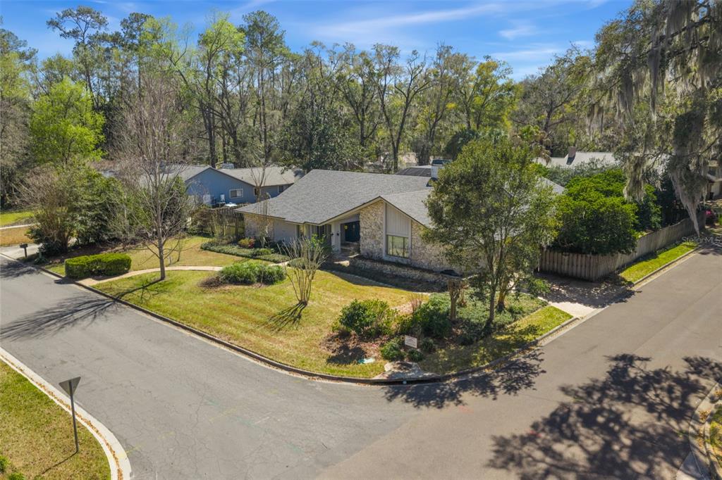 An exterior view of a single-story house with stone siding and a gray shingled roof — 2345 NW 14TH PLACE, GAINESVILLE, FL