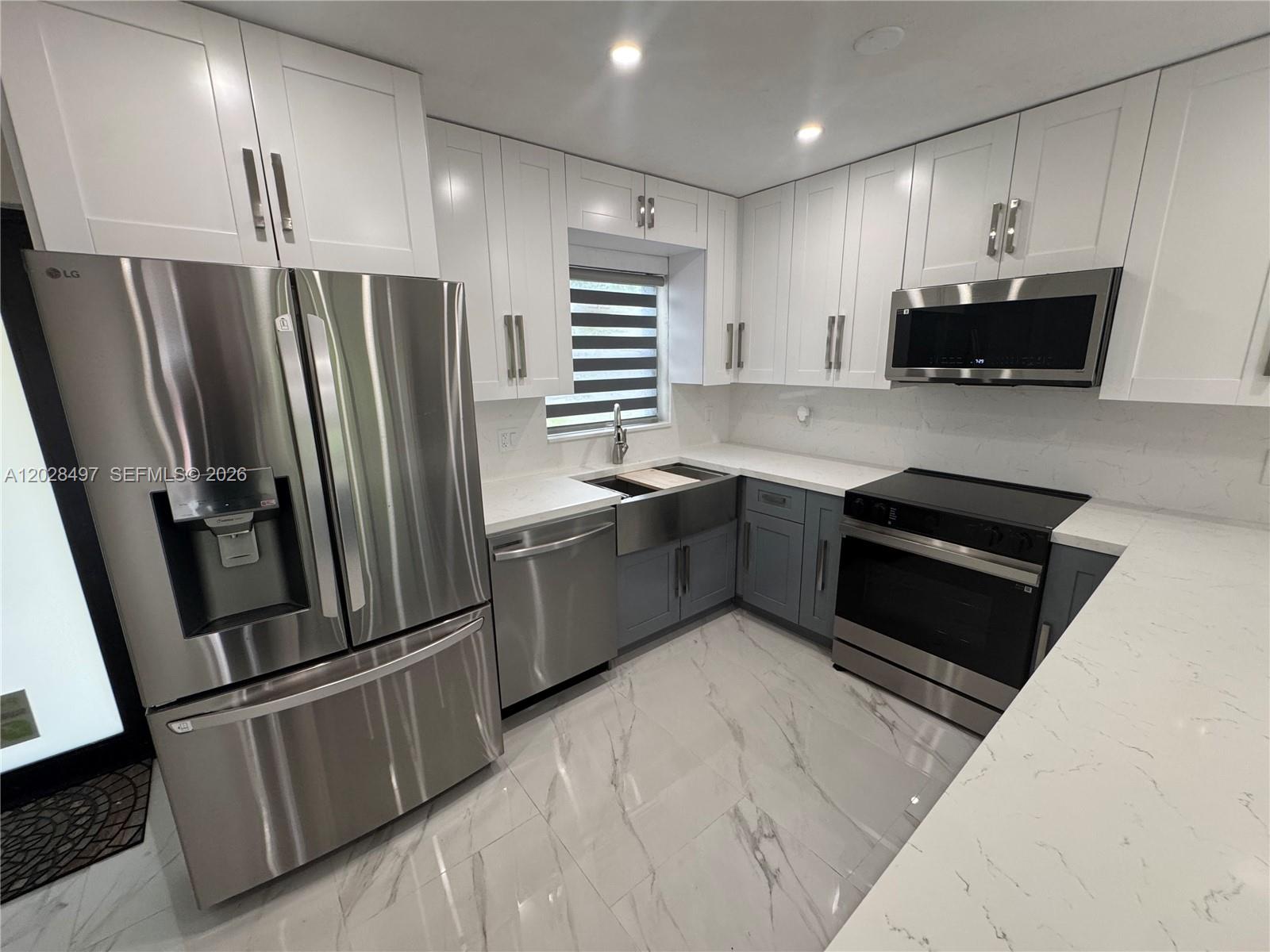 A single-story house features a red stamped concrete driveway, white gravel landscaping, and palm trees — 919 NE 4th Ct, Hallandale Beach FL 33009, HALLANDALE BEACH, FL