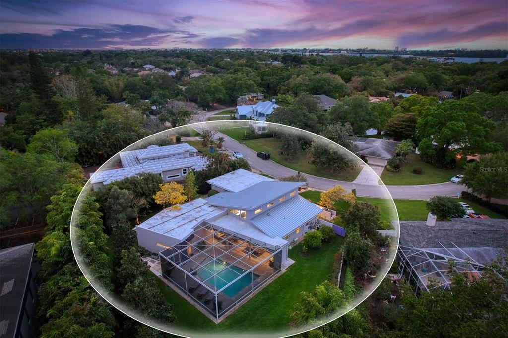 An aerial view of a modern house with a screened-in pool and metal roof — 1556 EASTBROOK DRIVE, SARASOTA, FL
