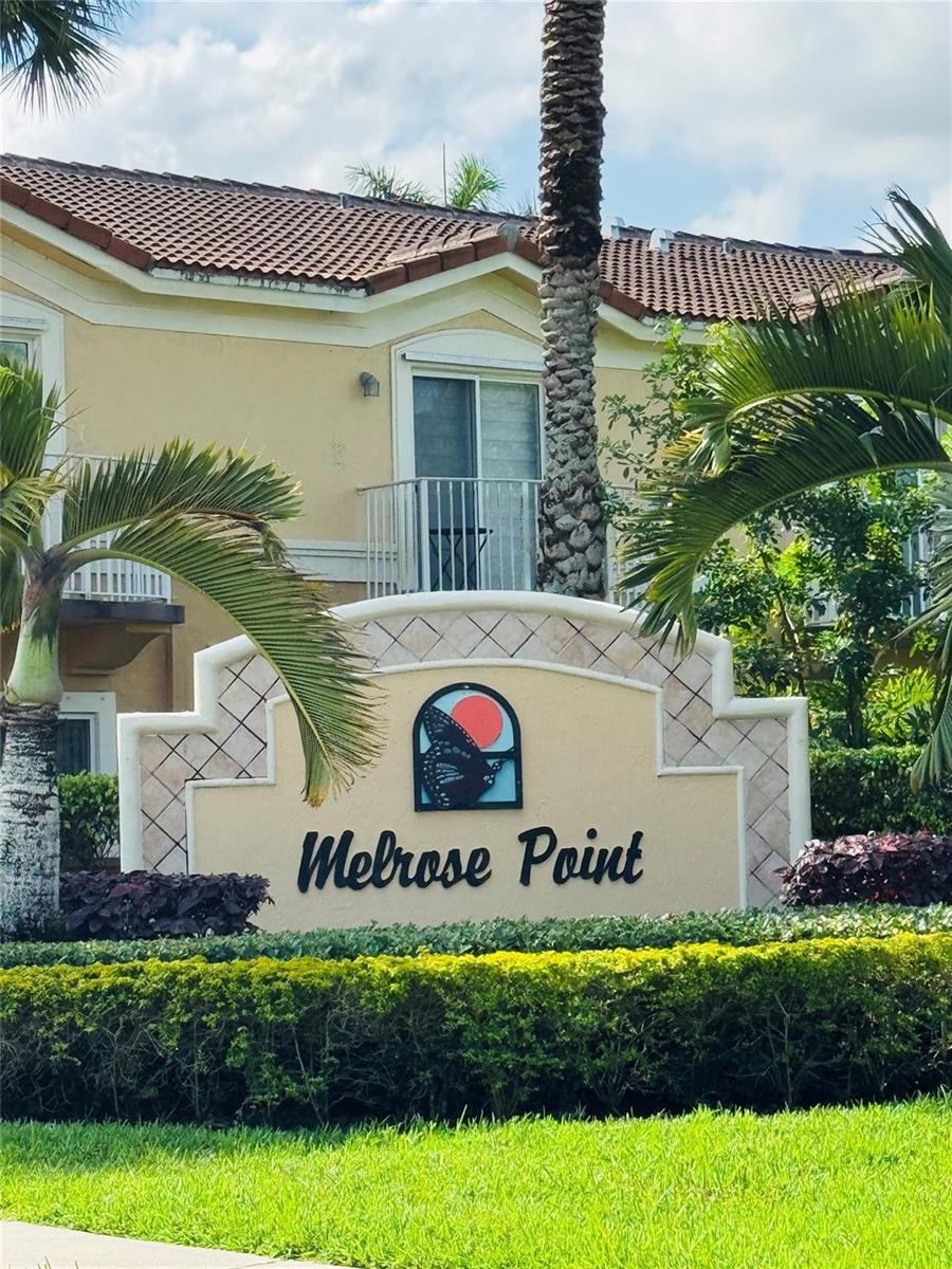 A beige stucco apartment building stands behind a sign for Melrose Point with palm trees — 3142 SW 129th Way # 156, Miramar FL 33027, MIRAMAR, FL
