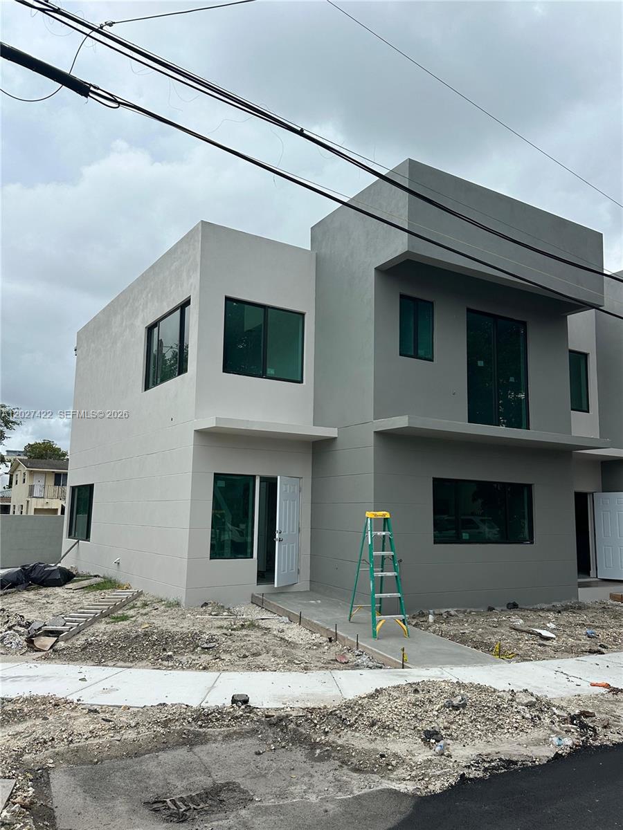 A modern two-story duplex with gray stucco exterior walls and a green step ladder — 6480 NE 1st Ave, Miami FL 33150, MIAMI, FL