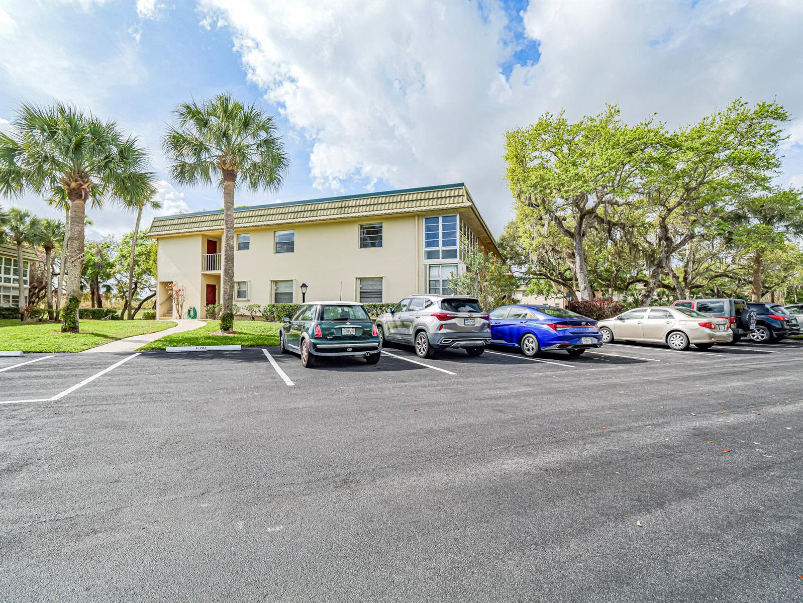 A multi-story apartment building with a parking lot in the foreground — VERO BEACH, FL