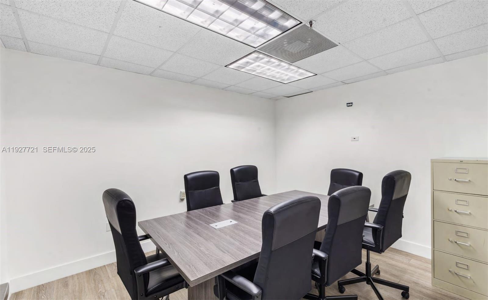A small conference room features a gray wood-grain table, six black chairs, and a filing cabinet — 66 W FLAGLER ST # 502, Miami FL 33130, MIAMI, FL