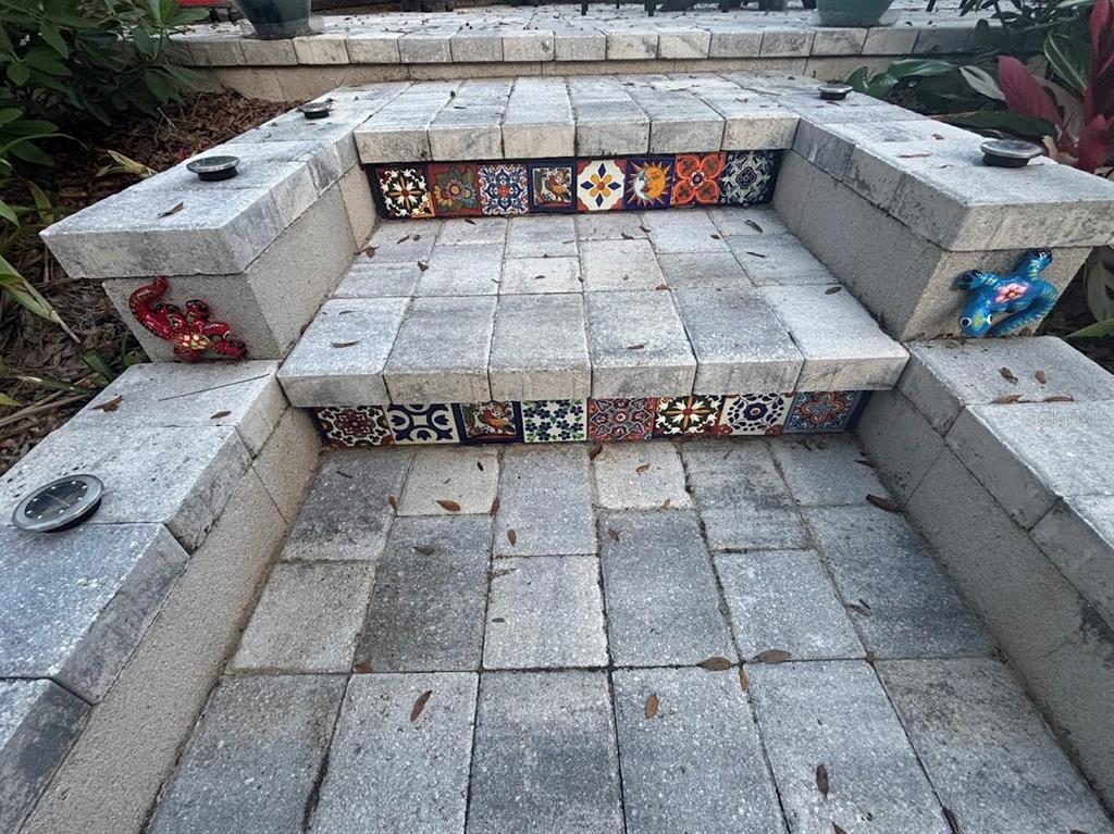 Outdoor stone steps feature decorative tile risers and colorful lizard accents on the side walls — 25244 NE 143RD  ST UNIT 180, SALT SPRINGS, FL