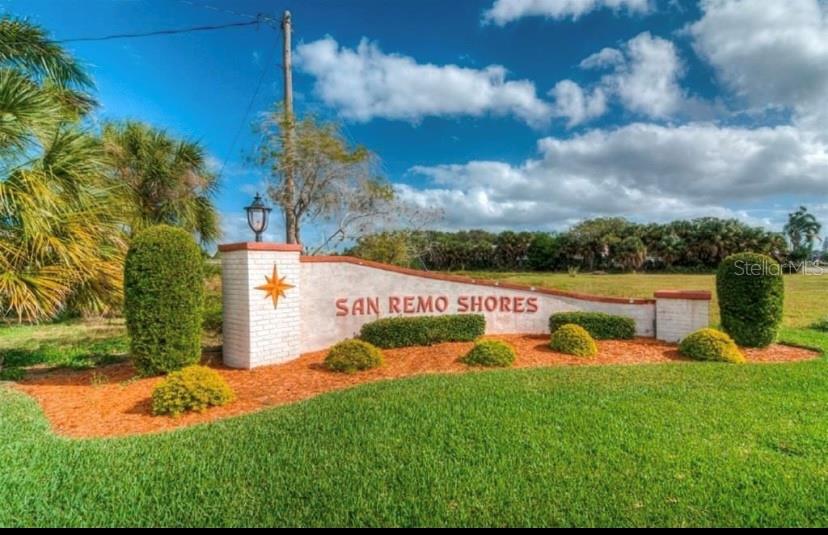 A white brick monument sign for San Remo Shores sits in a grassy field — 3708 ROYAL PALM DRIVE, BRADENTON, FL