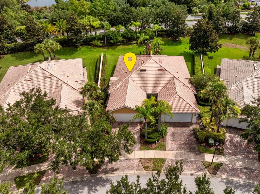 An aerial view shows a residential duplex with a tiled roof and brick paver driveway — 11740 ASTILBE DRIVE, ORLANDO, FL