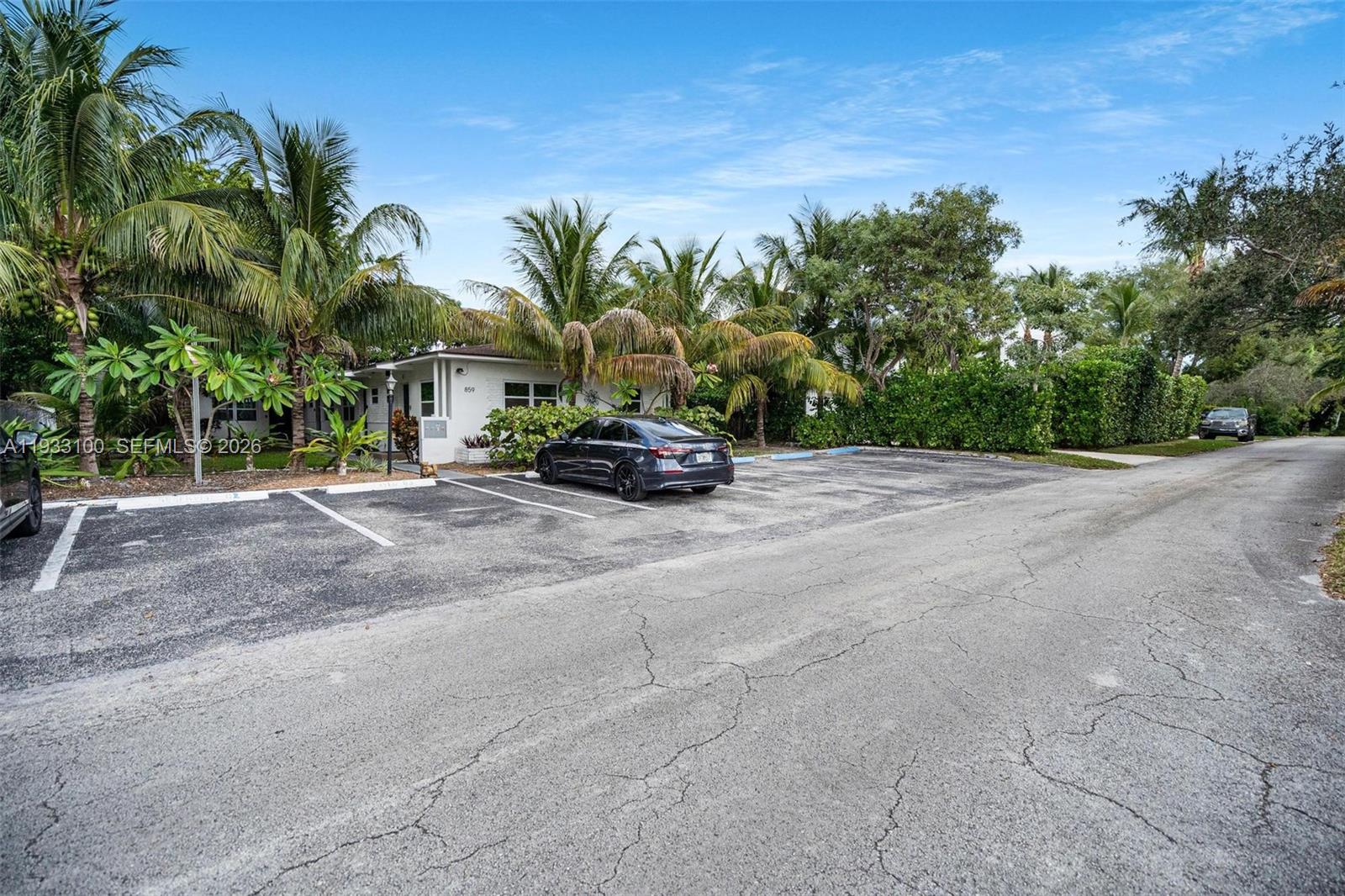 A single-story building with a parking lot and palm trees under a blue sky — 859 NE 90th St, Miami FL 33138, MIAMI, FL